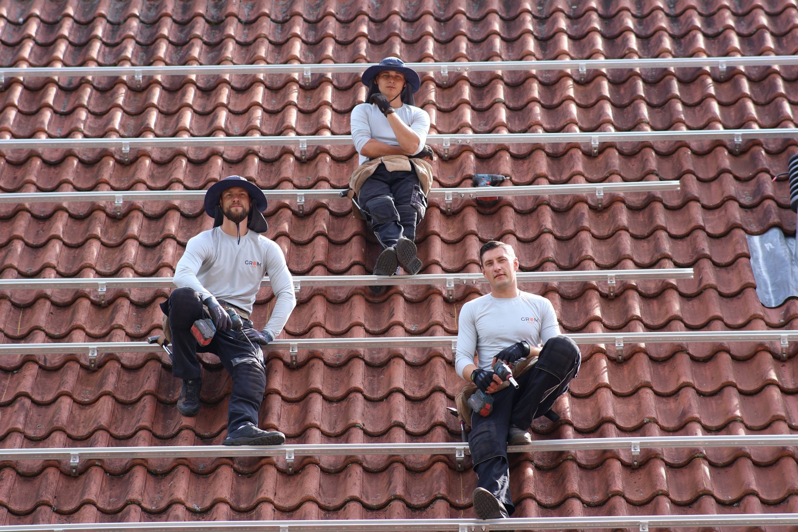 Montageteam von Grom Solar auf einem Hausdach bei der Vorbereitung einer Photovoltaikanlage.